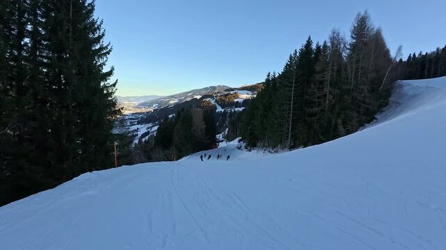 Gruppe von Skifahrern bei gemeinsamer dynamischer Abfahrt auf der Piste in Schladming
