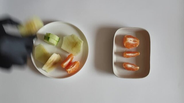 Hand Placing Apple Slices on White Plate &mdash; Fresh Fruit Concept