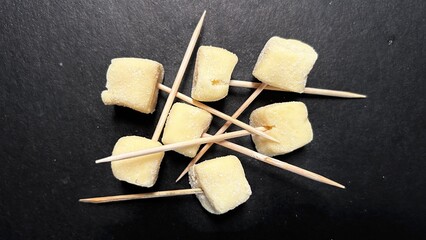 Milk Candy Cubes on Toothpicks on Dark Background