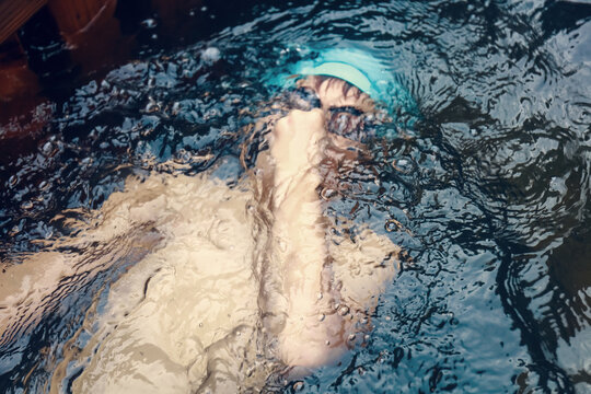 a boy practicing breath-holding in a swimming pool