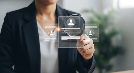 Businesswoman reviewing candidate profiles on a digital screen with a magnifying glass
