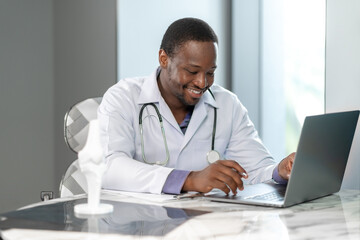 Professional doctor working with a laptop in a modern clinic office, focusing on healthcare management and online medical services for patients with digital technology support.