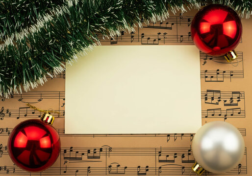 Christmas Card Template on Sheet Music with Ornaments, copy space for holiday greetings or announcements related to music and carols.
