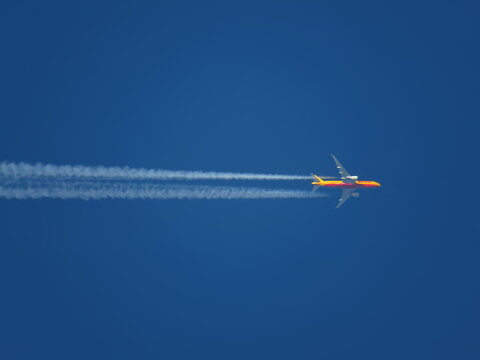 Feb 21, 2021. Lincolnshire, UK: a DHL cargo aircraft flying at high altitude in a clear blue sky with contrails