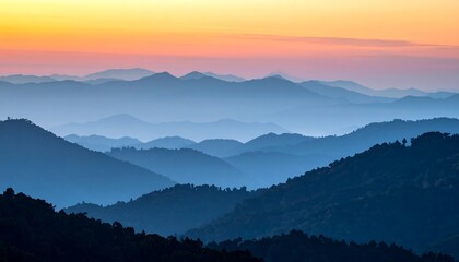 A scenic panorama capturing layers of blue mountains fading into the horizon as the sky transforms with warm sunset hues