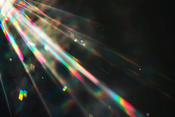 Colorful prism light rays scattering through dark background creating rainbow reflection