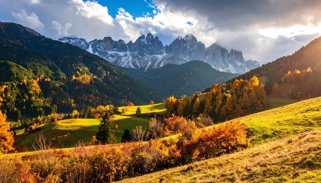 Stunning autumnal scene of rolling hills and majestic snow-capped mountains basking in the golden light of the setting sun