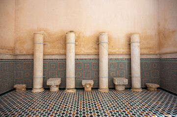 Roman columns with decorative capitals standing inside the Mausoleum of Moulay Ismail in Meknes, Morocco. The ancient stone contrasts beautifully with the ornate Moroccan architecture surrounding it.
