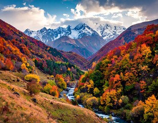 Colorful autumn mountains scene, with a river flowing through a valley and snow capped peaks