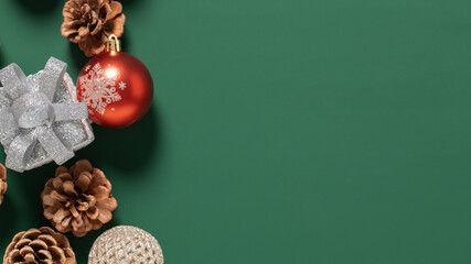christmas ball and pine cone on green background,christmas decoration with gift box on a green...