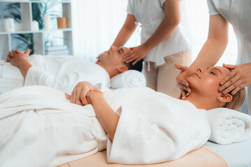 Caucasian couple enjoying relaxing anti-stress head massage and pampering facial beauty skin...