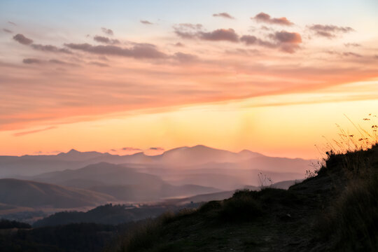 Beautiful sunrise over mountain hills with soft colors and misty atmosphere. Concept of new beginnings, inspiration, peace, motivation, and achieving life goals.