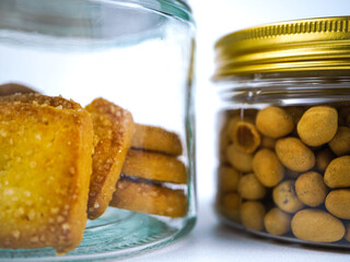 Delicious sugar coated biscuits and crunchy coated peanuts stored in clear glass jars ready for snacking anytime