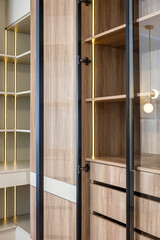 closet made of wood with led lights and glass doors