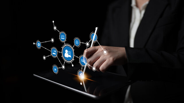 A business professional interacts with a touchscreen tablet, displaying networking icons that symbolize digital communication and modern technology in action. Tessel
