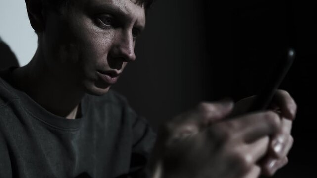 Man texting during relationship conflict, intense digital argument in the dark room