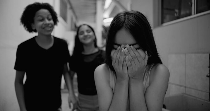 Teenager feeling vulnerable while being laughed at by friends in suburban alleyway, exploring themes of emotional vulnerability, bullying, and youth dynamics