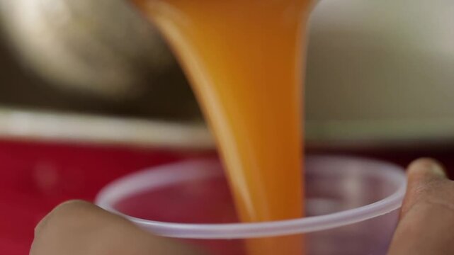Closeup shot of Pouring Wood apple juice in a glass.