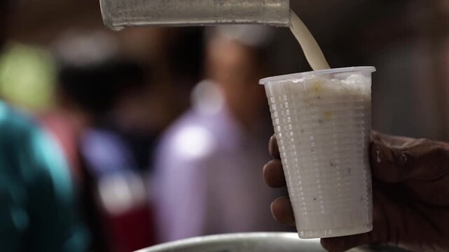 Pouring buttermilk in glass. Delicious summer drink buttermilk. 