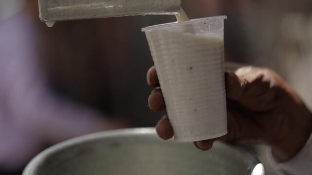 Pouring buttermilk in glass. Delicious summer drink buttermilk. 