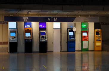 Various bank ATMs in different colors are installed at a gas station for customer convenience 