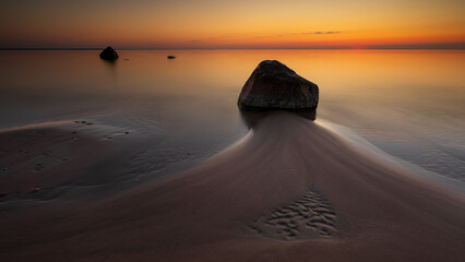 Sunset seascape with rock on sandy beach in Lahemaa National Park, Estonia.