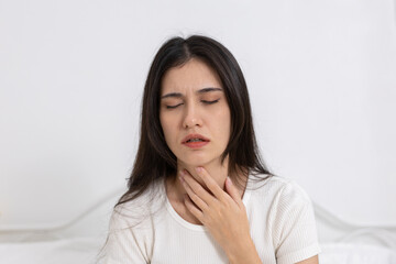 Fototapeta premium women touching her throat with painful expression, suffering from sore throat, tonsillitis, respiratory infection. Concept of cold, flu or viral illness.