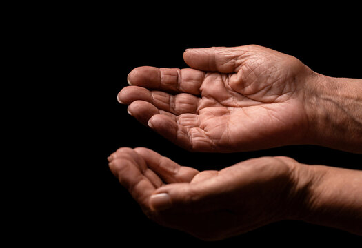 Old man hands on a black background. Elderly lady is waiting for help. Elderly, aging concept. Wrinkled hands palms reaching out forward. Old lady arms
