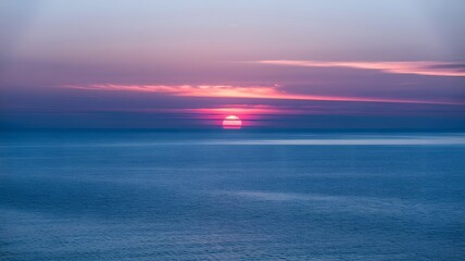 Vibrant sunset over the ocean with pink and blue colored sky view