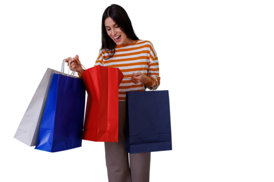Woman holding assorted shopping bags, expressing excitement and surprise while looking inside. Transparent background - Powered by Adobe