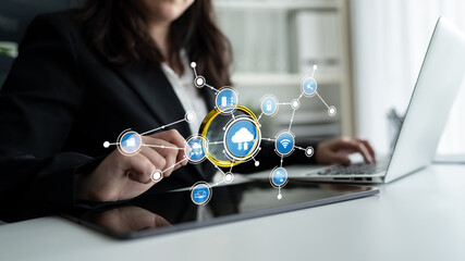 A businesswoman interacts with cloud technology visuals on a tablet in a sleek office, emphasizing innovation and digital transformation in the workplace. Tessel