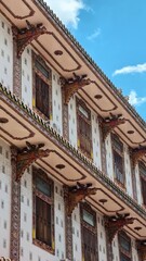 Naklejka premium Traditional Chinese Architectural Detail with Carved Dragon Brackets and Wooden Windows