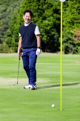 ゴルフを楽しむ日本人のミドル男性