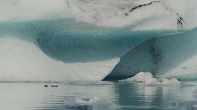 view of a large, ancient iceberg with stunning blue hues floating calmly in the J&ouml;kuls&aacute;rl&oacute;n glacial lagoon in Iceland