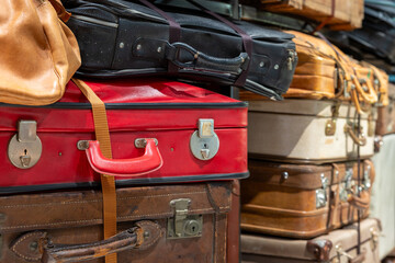 Multiple colorful old suitcases stacked in storage
