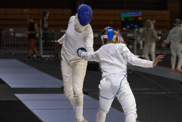 Two female fencing athletes fighting