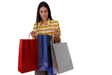 Woman standing with multiple shopping bags, checking purchased items with a happy expression. Transparent background