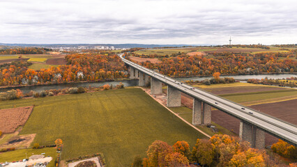 Aerial view of highway bridge over Danube near Regensburg autumn forest and calm river forming a...