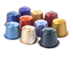 A cluster of metallic coffee pods in various colors, displayed against a white background, showcasing texture