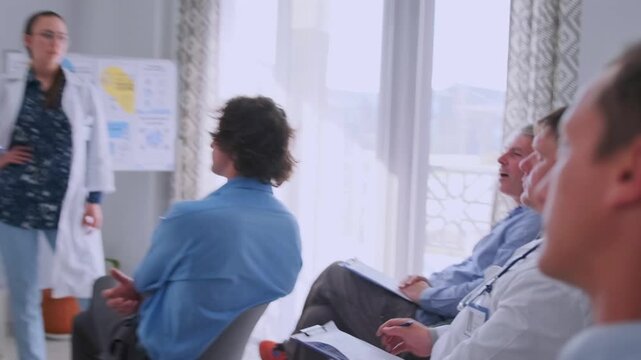 Physicians in lab coats explain new treatments and respond to audience questions during neurosurgery and medicine presentation.