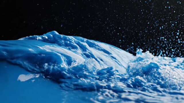 Closeup of Blue Water Wave Breaking Against Dark Surface in Slow Motion