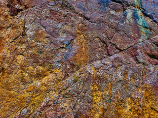 Aubergine red coloured rock patterns with orange colored iron deposits. Abstract texturized shapes.