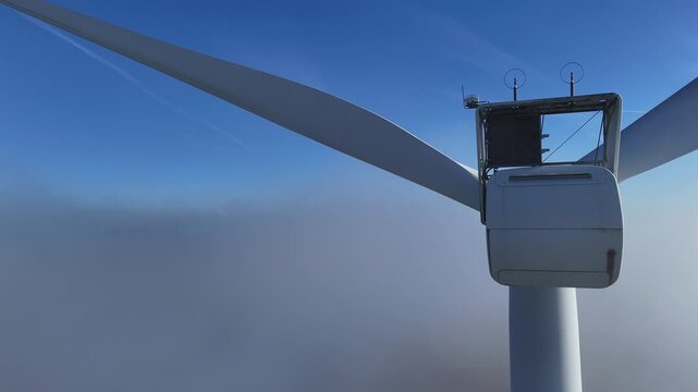 Une &eacute;olienne &eacute;merge au dessus d'un banc de brouillard, au mois de novembre, en automne, sur un beau ciel bleu. Parc &eacute;olien de Doncourt-les-Longuyon, en Meurthe et Moselle, Lorraine.