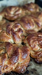 A close-up of warm, freshly baked cinnamon rolls, golden brown and glistening with a sweet glaze.