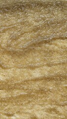 A macro, top-down view of a wet, glistening cinnamon and sugar filling or batter, creating an abstract food texture.