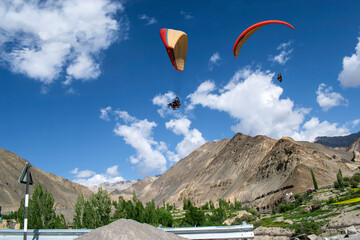 Tourists paragliding at Leh Ladakh with view of Himalayan mountain range.