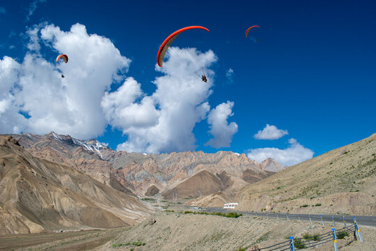 Tourists paragliding at Leh Ladakh with view of Himalayan mountain range.