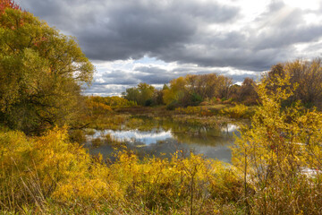 A tranquil fall scene along Ontario's Long Sault Parkway, capturing the vibrant autumn colors and serene reflections of the landscape.