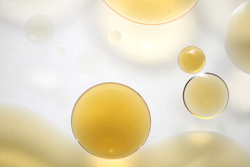 Yellow Oil Droplets Floating in Water with Soft Light Background