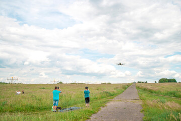 A plane is approaching for landing. People are taking pictures of the plane in flight